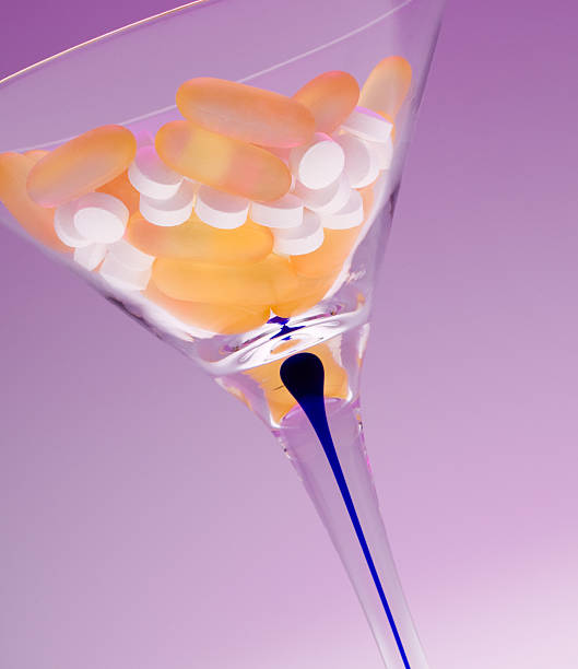 inclinar taça de martíni com pílulas - gel effect capsule pill vitamin e - fotografias e filmes do acervo