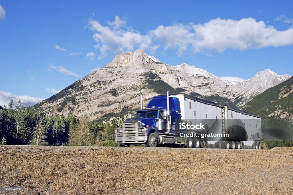 truck going up-hill a semi truck going up through the Canadian Rockies with motion blur Canada Stock Photo