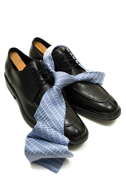 Men's Accesories Men's leather shoes and a silk necktie with a knot on white background- men's accesories oxford michigan photos stock pictures, royalty-free photos & images