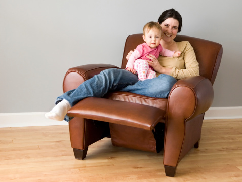 Mother and relax together in a leather recliner chair.