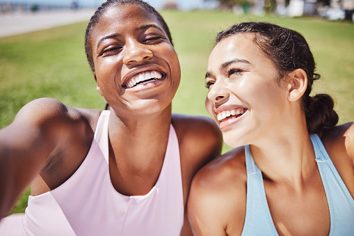Interracial woman, fitness and friends smile for sports exercise, workout and training together in nature. Happy active women smiling for selfie in happiness for healthy friendship in South Africa