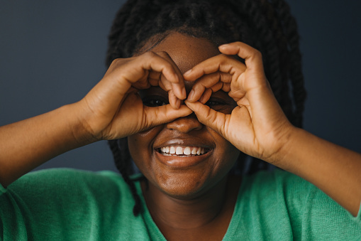 Headshot of black woman using fingers to create binoculars