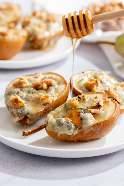 istock Baked pears with blue cheese, walnuts and honey on white plate and light background 1793086521