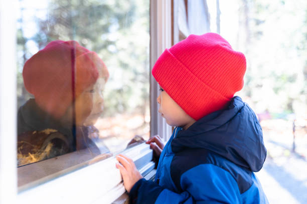 istock Window of Curiosity: Inquisitive Boy Peeks Through and Explores the World 1793090742