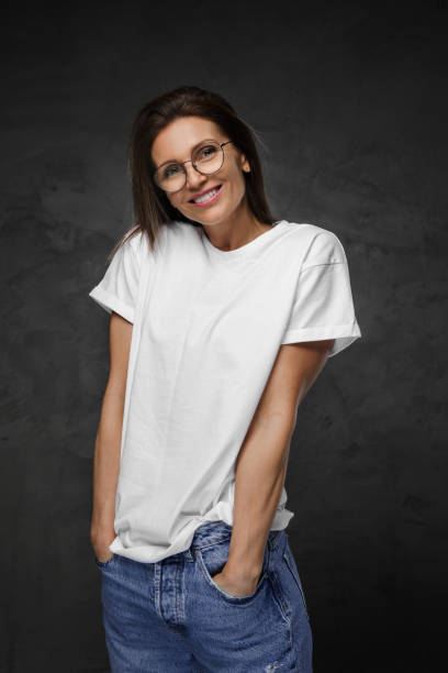 istock Female in spectacles and white tee beams brightly with a moody backdrop 1793104640