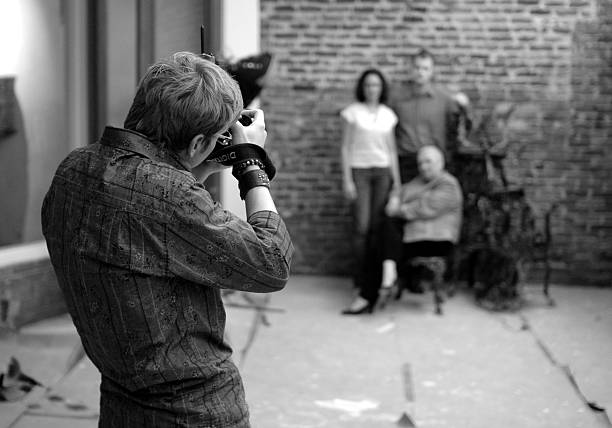 Photographer and family in B&W "A photographer shooting a couple and their mother in a renovated restaurant, in black & white." black and white portrait photographers stock pictures, royalty-free photos & images