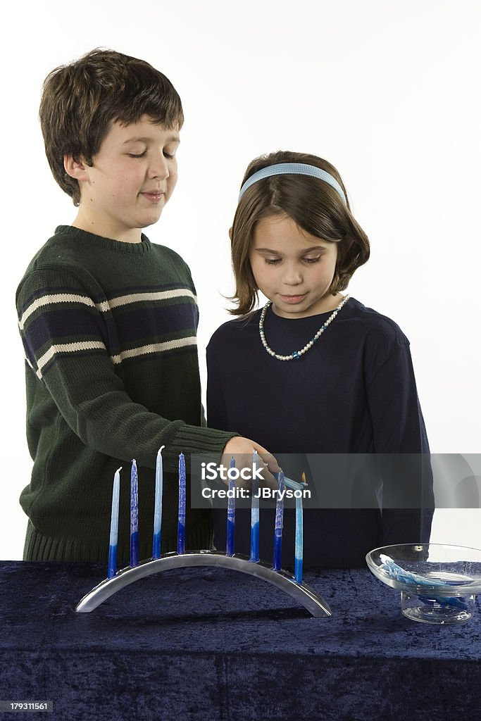The Eighth Day of Chanukah Jewish brother and sister light the menorah on the eighth day of Chanukah. Child Stock Photo