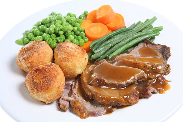 istock Roast lamb with gravy with vegetables and rolls on a plate 179311750