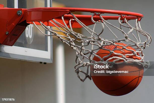 A Basketball Dropping Through A Net Stock Photo - Download Image Now - Basketball Hoop, Basketball - Ball, Basketball - Sport