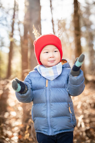 Cute little boy having fun and playing outdoors during snowfall