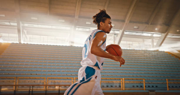 istock Man walking with basketball 1793136475