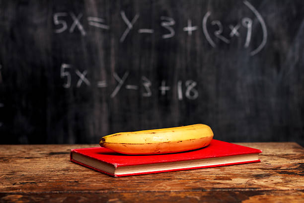 banana e libro da lavagna con equazione - reading and writing blackboard book elementary school building foto e immagini stock