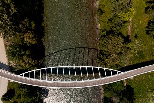Zenith view of a modern arch shaped design pedestrian bridge over the Ticino river in Switzerland. Nobody inside