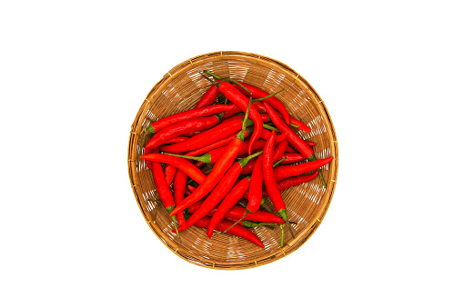 A lot of red hot chili pepper in weave basket isolated on white background and top view. Freshness vegetables