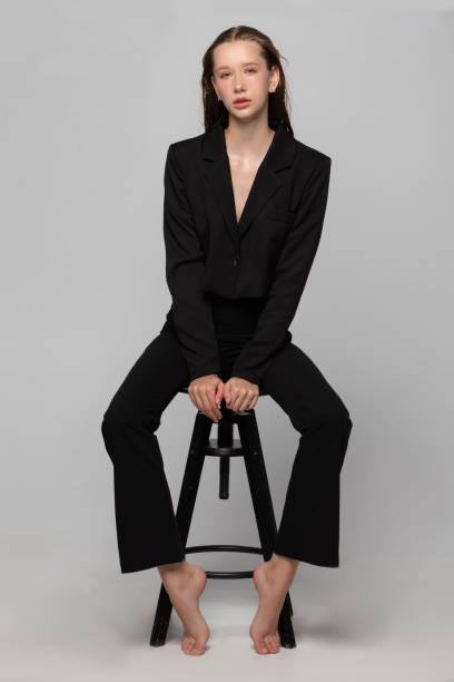 istock A beautiful slender girl in a black suit posing in the studio. 1793159978