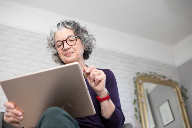 istock Woman sitting on a bed and using a digital tablet 1793160656