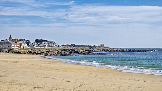 The walled city of Saint-Malo, France, with granite residential buildings protruding above the rampart and the Mole beach at the foot of the fortifications, seen from the breakwater.