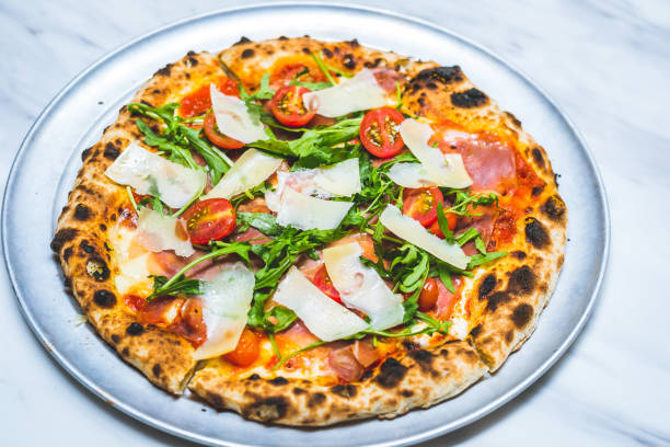 istock Neapolitan style pizza with cheese, patma ham, arugula, tomato sauce and cherry tomatoes 1793178793