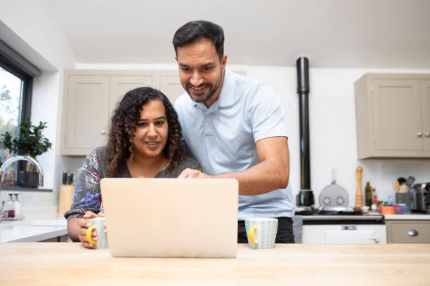 istock Man and woman using a laptop computer in a kitchen 1793186462
