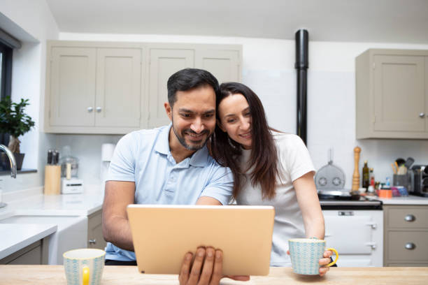 istock Man and woman using a digital tablet in a kitchen 1793187650