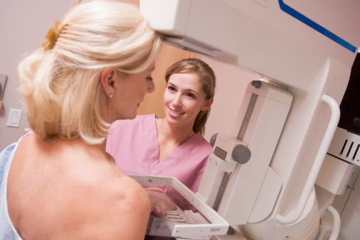 Nurse Assisting Patient Undergoing Mammogram In General Practise