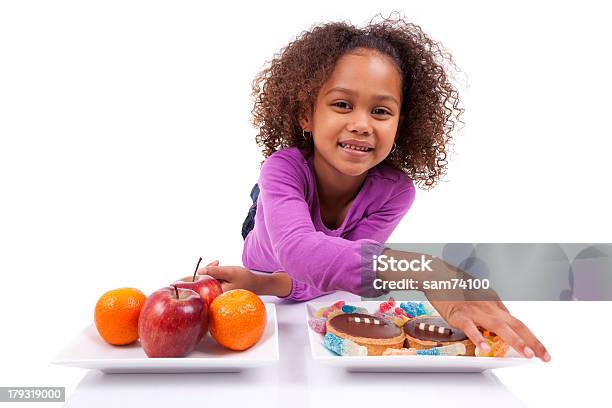 Kleine Afrikanische Asiatische Mädchen Hesitating Zwischen Obst Und Süßigkeiten Stockfoto und mehr Bilder von Abnehmen