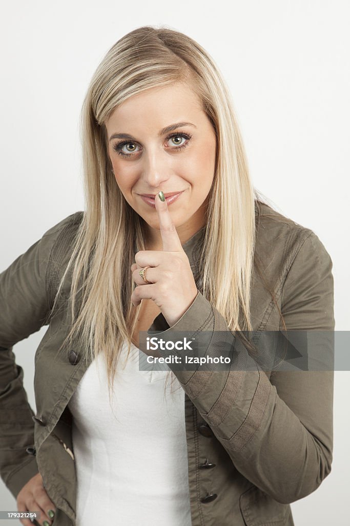 Portrait d'une jeune femme souriant et posant pour le silence - Photo de Adulte libre de droits