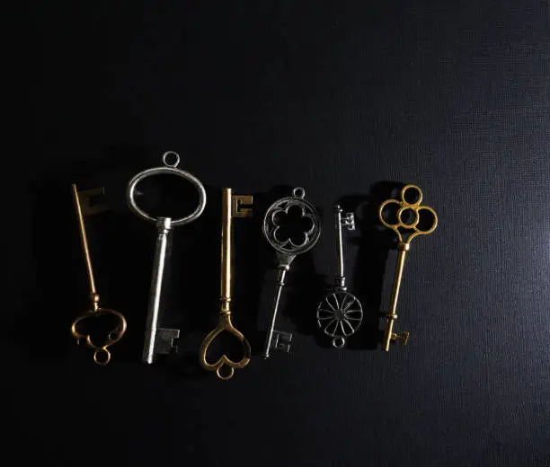 Assorted gold and silver vintage keys on dark background