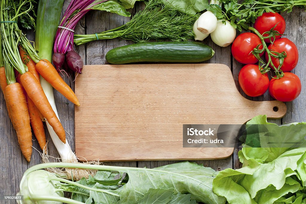 Muchas verduras orgánicas frescas y vacío tabla de cortar - Foto de stock de Agricultura libre de derechos