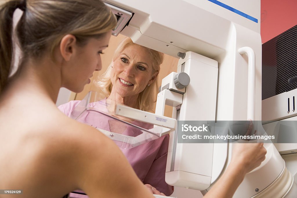Infermiera aiutando il paziente sottoposto a mammografia - Foto stock royalty-free di Accudire