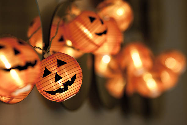 Close-up string of pumpkin lights moving out of focus Halloween halloween pumpkin decorations stock pictures, royalty-free photos & images