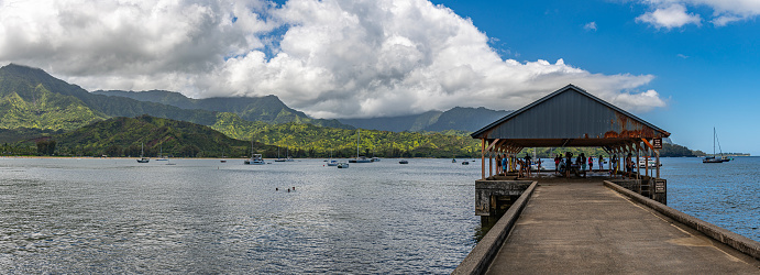 Hanalei, Kauai June 17, 2023 Panoramic view of Hanalei Bay with the pier with blue skies and white clouds on Kauai, Hawaii, United States.