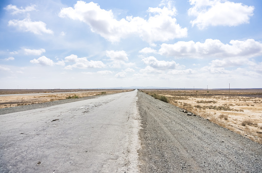 Asphalted highway in the middle of the desert in Uzbekistan, bad road in the desert