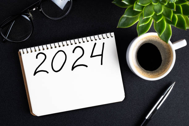 istock 2024 New year resolutions on desk. 2024 goals list with notebook, coffee cup, plant on black table. Resolutions, plan, goals, action, checklist, idea concept. New Year 2024 resolutions 1793288499