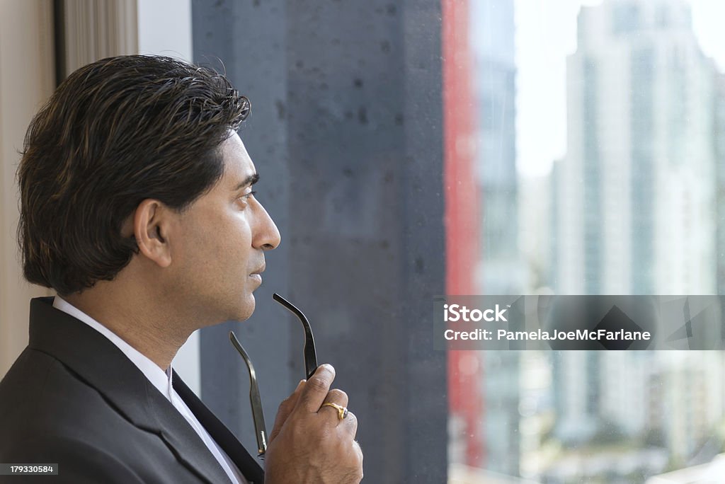 Un homme d'affaires regardant par la fenêtre de un grand immeuble de bureaux - Photo de Fenêtre libre de droits