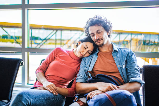 istock Couple of exhausted passengers sleeping while waiting at the airport 1793308909
