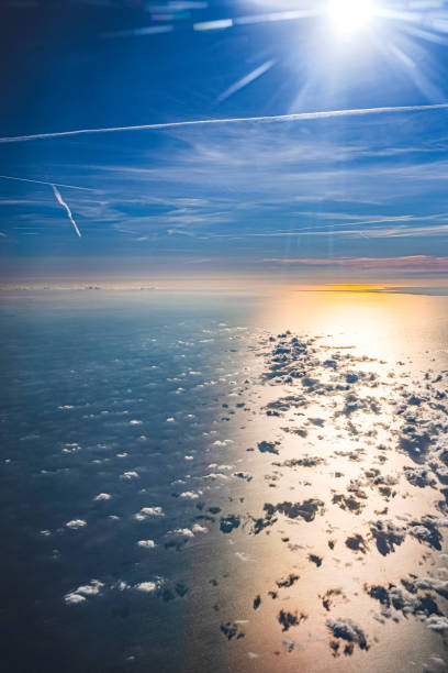 View of sky and horizon over water from flying airplane