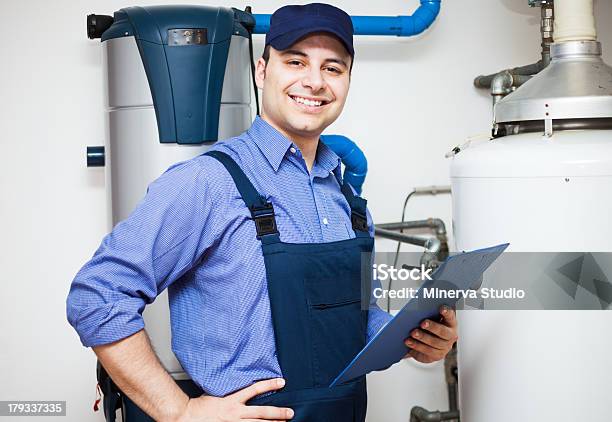 Technician Servicing An Hotwater Heater Stock Photo - Download Image Now - Plumber, Customer, Pipefitter