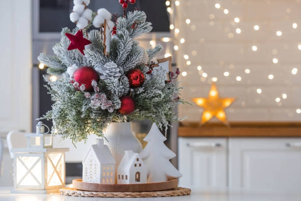 istock A spruce bouquet with red berries, toys, cotton on a white kitchen table against a beautiful garland. Christmas decorations in the interior. The concept of preparation for the New Year holidays 2024. 1793383802