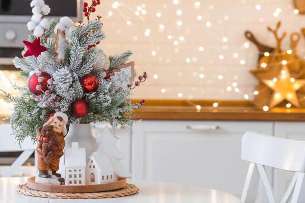 istock A spruce bouquet with red berries, toys, cotton on a white kitchen table against a beautiful garland. Christmas decorations in the interior. The concept of preparation for the New Year holidays 2024. 1793388896