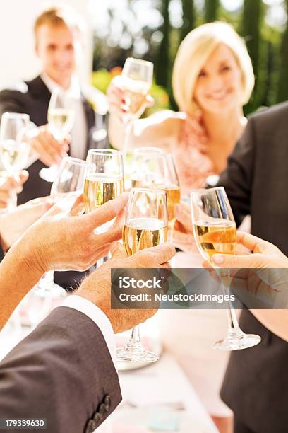 Guests And Couple Toasting Champagne Flutes During Reception Stock Photo - Download Image Now