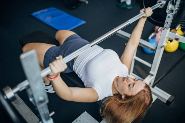 istock Young woman exercising on bench press 1793434890