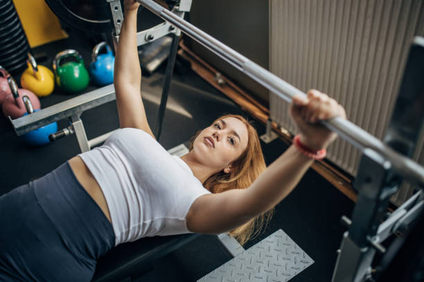 istock Young woman exercising on bench press 1793435103
