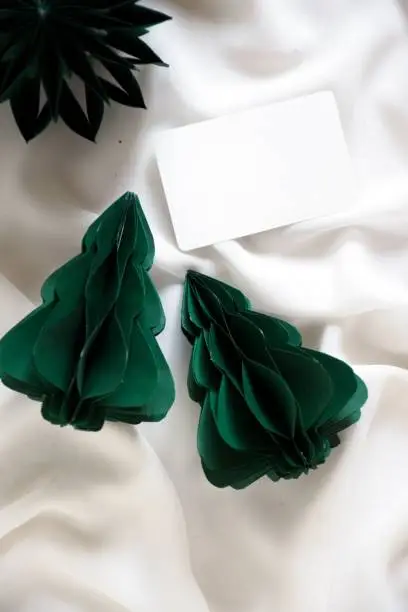 Two pieces of white paper are set side by side against a background of green foliage