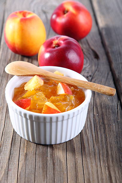 nectarines and jam on wooden background stock photo