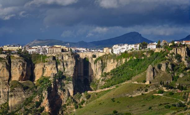 istock mountains and a building with people walking on it with clouds in the sky 1793471096