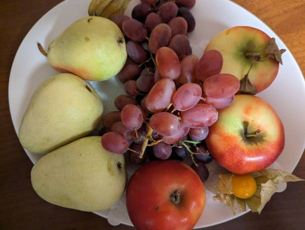 istock Plates with different types of fruit on the wooden table. 1793475377