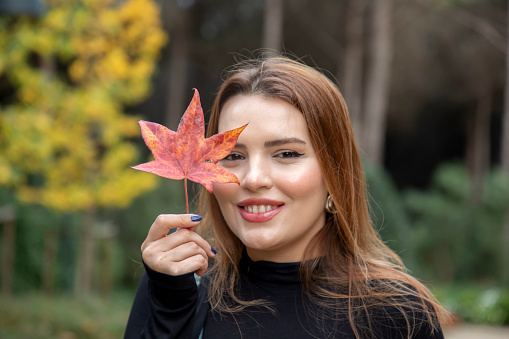 A young beautiful blonde woman in a public park in autumn