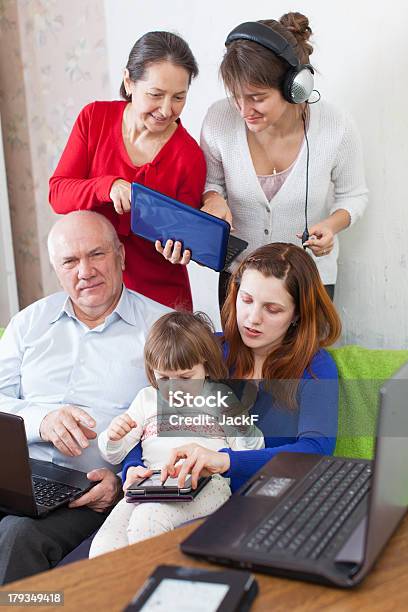 Happy Family Utiliza Diversos Dispositivos Electrónicos En Su Hogar Foto de stock y más banco de imágenes de 50-59 años
