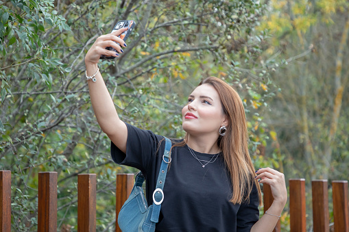 Beautiful blonde woman taking selfie in nature